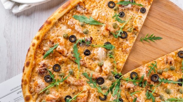 gambar pizza panggang dengan topping daging dan sayur diatasnya